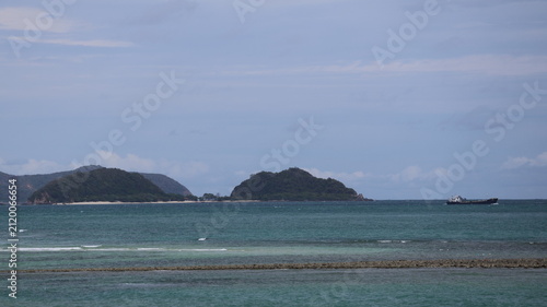 The image depicts a tranquil seascape with a calm, expansive body of water stretching toward the horizon