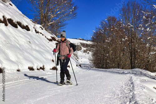 Une femme en randonnée en raquettes de neige en hiver