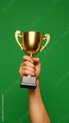 Hand Holding Golden Trophy Cup on Green Screen Chroma Key Background, Winner Award, Employee of the Month, Success Achievement, Victory Celebration, Vertical Video Overlay