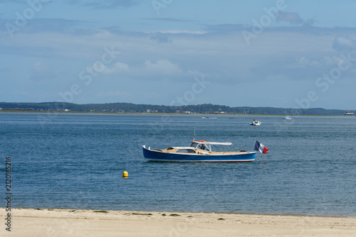 Foto Blue boat with French flag navigating Arcachon Bay