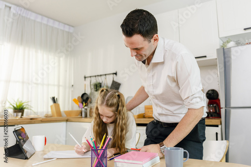 Father guiding his daughter during a drawing lesson at home, with a tablet, colored pencils, and books, representing homeschooling, parenting support, creativity, education, and family bonding.