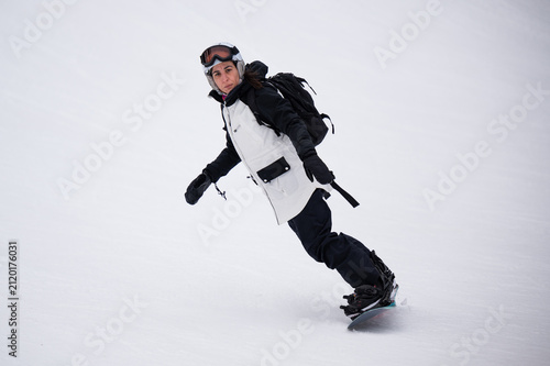 Obraz na płótnie Woman snowboarding down mountain slope enjoying winter sports