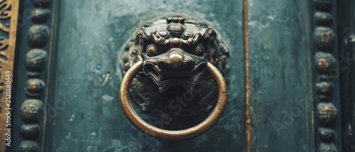Traditional ancient Chinese bronze dragon lion head door knocker on dark green vintage wooden entrance