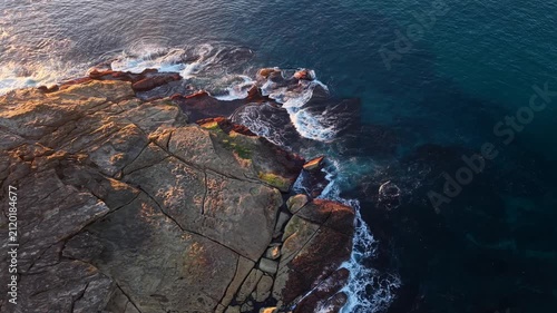 Aerial view of rocky coastline with blue ocean.