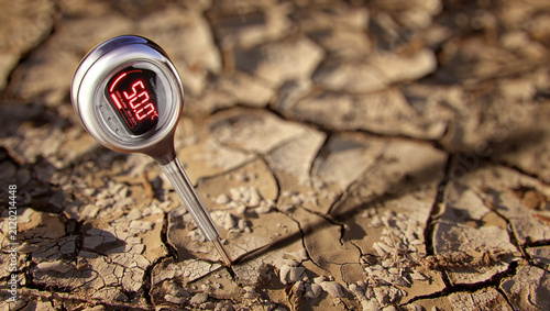 Fotografie Digital thermometer measuring extreme heat in cracked dry soil, climate change,