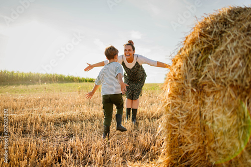 Mom and son hugging on a hay bale