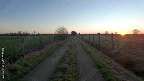 Cinematic Reverse Motion on a Rural Dirt Path During a Beautiful Golden Hour Sunset or Sunrise