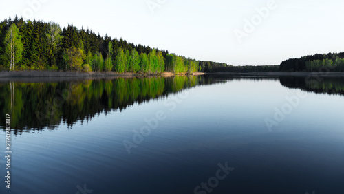 Calm landscape scenery, lake with tree forest on the coast