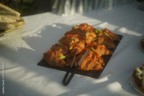 Bild auf Leinwand Fresh croissant sandwiches with lettuce and tomato displayed on a tray for a cat