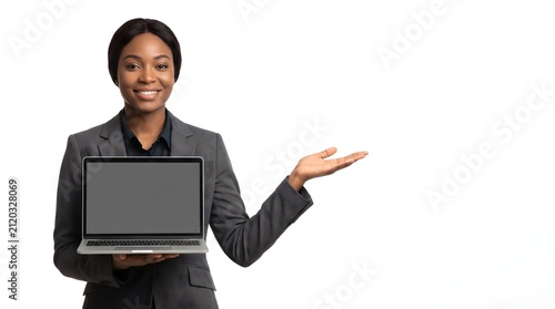 Professional African American businesswoman holding a laptop and gesturing to empty copy space.