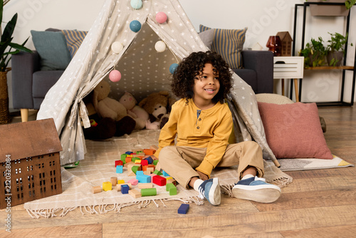 Foto Happy moments of a cheerful boy enjoying playtime at home in a cozy apartment