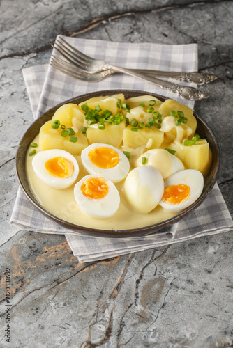 Konstfotografi Senfeier or mustard eggs is a traditional German egg dish with a creamy mustard sauce and hard-boiled eggs close-up in a plate on the table