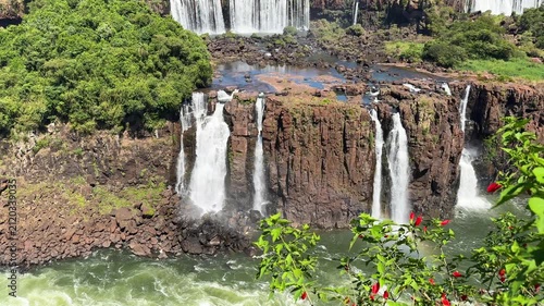 Scenic view of magnificent waterfalls cascading down rocky cliffs surrounded by lush green tropical rainforest vegetation