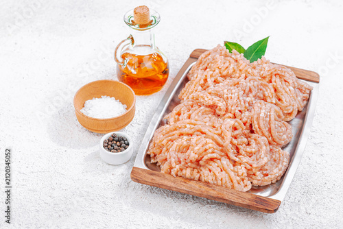 Canvastavla Raw ground meat on a metal serving tray with oil, sea salt, and peppercorns on a