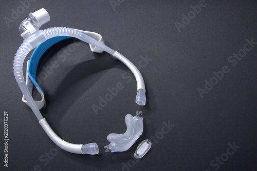 Disassembled CPAP nose mask or nasal CPAP cradle mask shows replaceable parts of CPAP headgear clip. Sleep apnea and sleep disorder with snoring stopped by respirator mask and CPAP machine treatment.