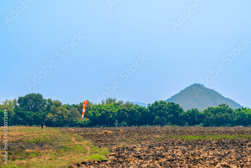 Foto Windsock indicator of wind in meadow with beautiful scenic