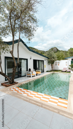Obraz na plátne Tropical Villa Retreat: A secluded villa features a pristine swimming pool, surrounded by lush greenery and modern architecture, offering a serene escape in a picturesque setting