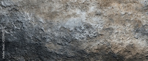 Close-up of weathered, textured rock with a gradient of dark gray to light brown