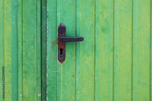 Old green metal door with lock and keyhole, closeup of photo