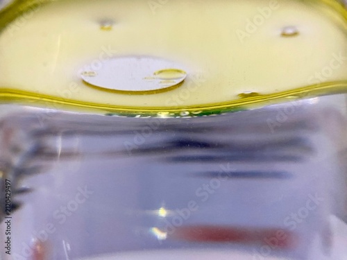 Macro close up of round yellow oil drop floating on water surface tension photo image for science chemistry fluid dynamics graphic element isolated