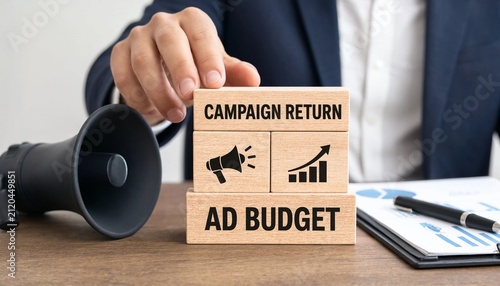 Professional placing wooden block emphasizing campaign return and ad budget with megaphone and clipboard