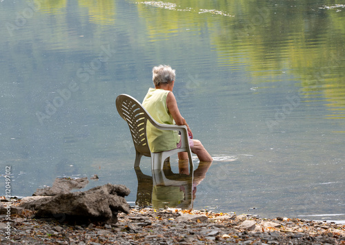 Seniorin kühlt sich während einer Hitzewelle im Rhein ab und genießt die Erfrischung im Wasser