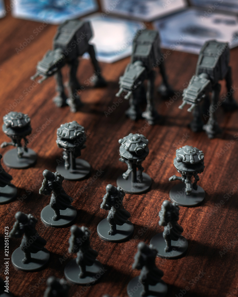 Fototapeta premium Imperial army miniatures assembled on a Battle of Hoth tabletop battlefield featuring AT AT walkers, scout droids and infantry captured with dramatic lighting in a cinematic perspective