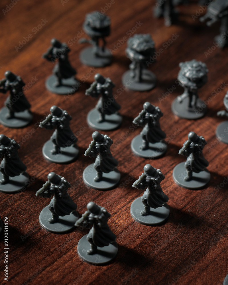 Fototapeta premium Imperial army miniatures assembled on a Battle of Hoth tabletop battlefield featuring AT AT walkers, scout droids and infantry captured with dramatic lighting in a cinematic perspective