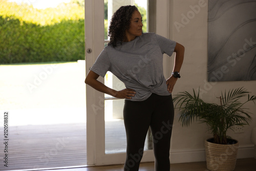 Fotografie African American woman standing in home doorway, wearing gray tee, showing smart