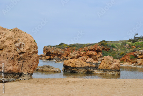 
sandy seaside beach and rocky cliffs