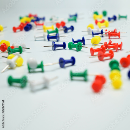 Fotografie multicolored push pins on white tabletop with copy space below