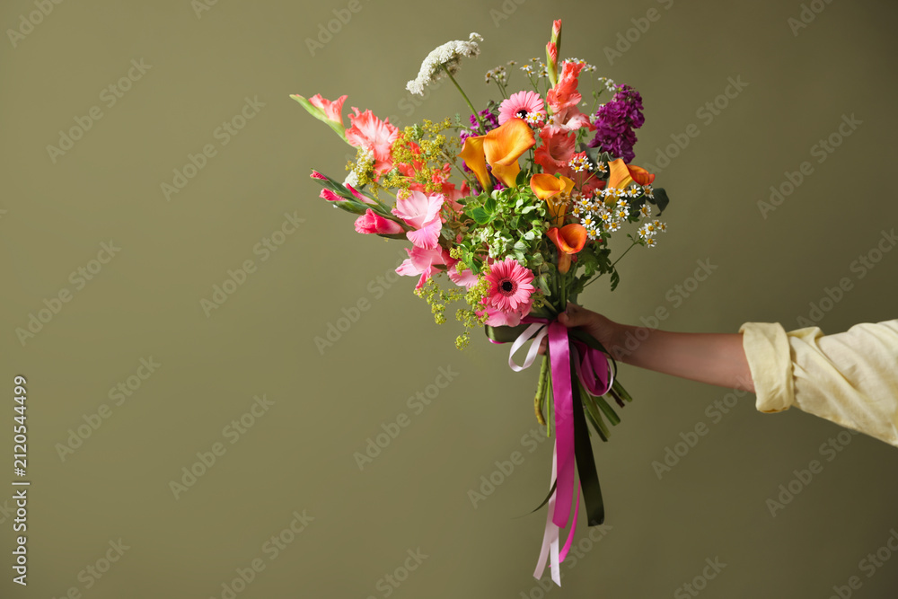Obraz premium Woman with bouquet of beautiful vibrant flowers on olive background, closeup. Space for text