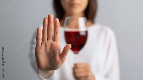 Person refusing red wine with a stop hand gesture, choosing sobriety and healthy lifestyle, abstaining from alcohol