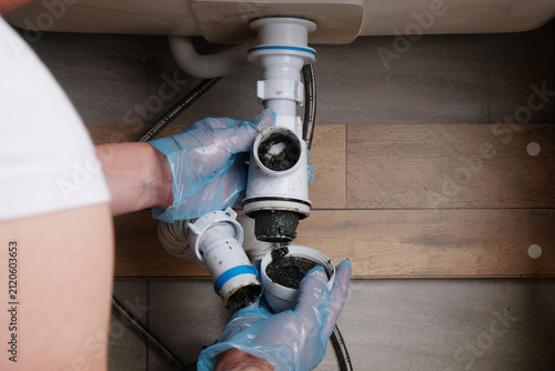 Konstfotografi Close-up of the process of dismantling and cleaning a plastic sink trap clogged with dirt and grease deposits