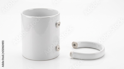 White ceramic mug with detached handle on white background with lying white surface copy space repairable dismantled minimalist porcelain with tableware
