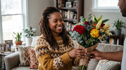 Smiling Black Woman Receives Beautiful Bouquet of Flowers Indoors from Partner