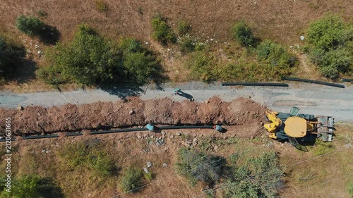 Aerial view of workers laying pipes and heavy machinery