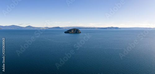 A scenic panoramic view of Motutaiko Island sitting in the middle of the expansive Lake Taupo in the Taupo District of New Zealand.