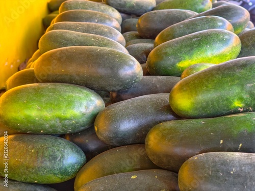 Fotografía Pile of fresh oblong dark green watermelons displayed at a fruit market