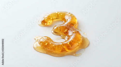 Number three is formed from a thick layer of golden honey resting on a smooth white surface.