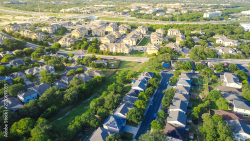 West Military Drive thoroughfare borders single family home developments and master planned community dense housing. Multi-family apartment complexes flank multi-lane roadways, San Antonio, TX