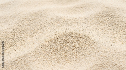 Close up of fine sand texture with gentle waves and shadows.