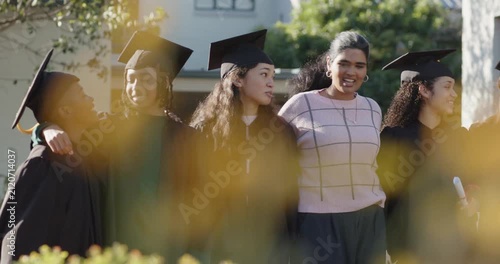 Diverse grads and Indian mentor stepping in, shifting caps, holding diplomas for campus portrait