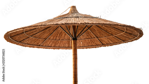 Beach umbrella made of dried natural straw provides shade during a sunny day at a tropical coastal resort location.