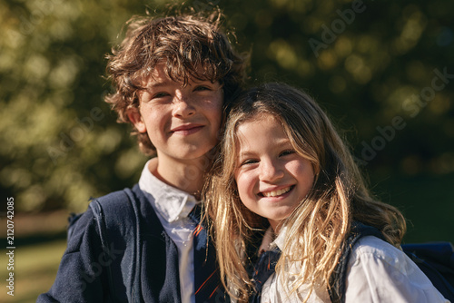 Young School Boy and Girl Standing Together in Green Park