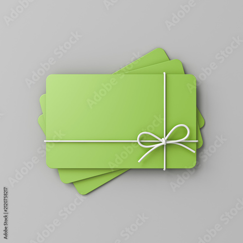 Stack of blank green pastel color business gift cards mock up with white rope bow isolated on gray background with shadow minimal conceptual 3D rendering