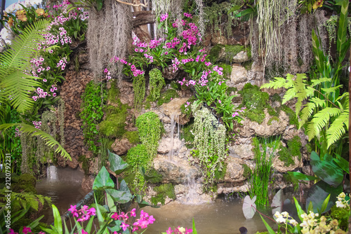 Water fall in colorful flower garden natural forest background