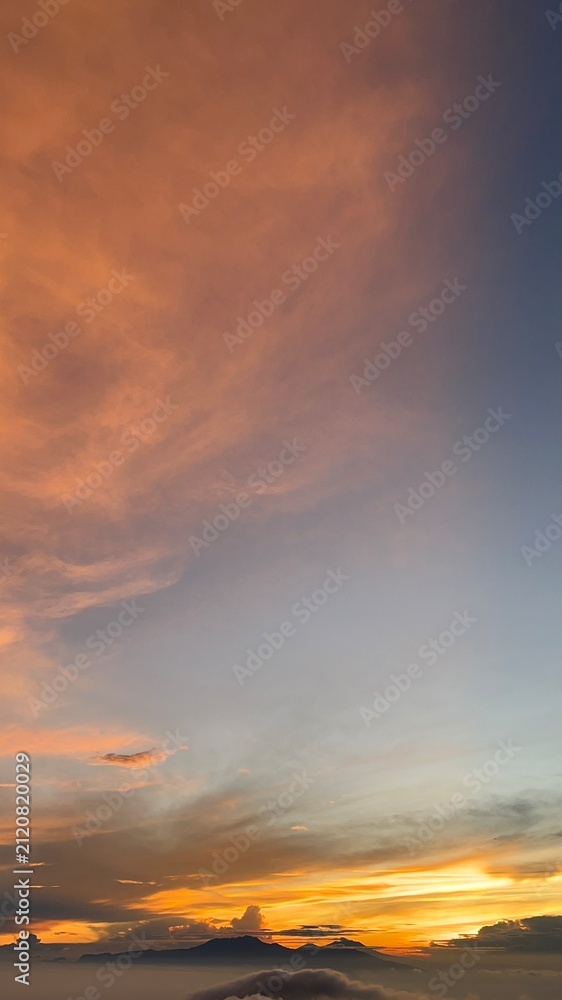 Fototapeta premium Dramatic Orange Sunset Sky Above Clouds And Mountain Peaks