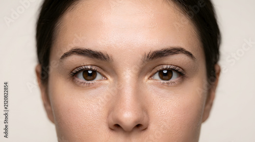 Close up portrait of a young woman with natural makeup looking at camera.