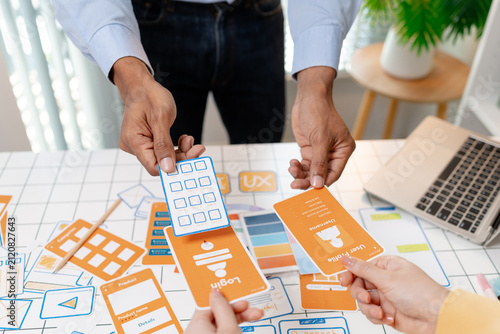 Bild auf Leinwand A UX design team collaborates with wireframes, interface cards, color palettes, and mobile app prototypes to improve user experience, design systems, product strategy, and digital innovation